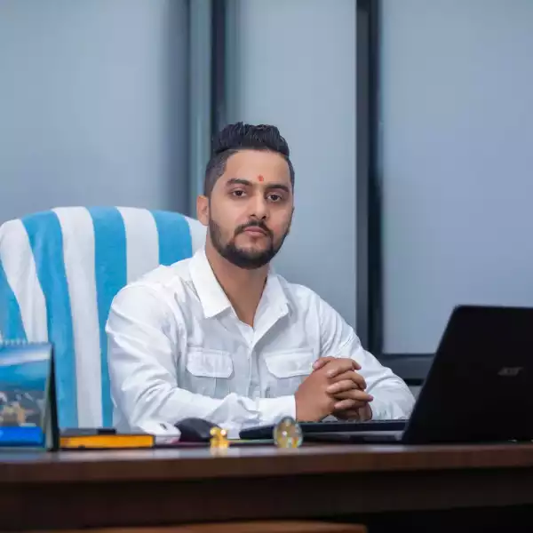 The CEO of Manakamana Beverage sitting in an office chair, facing the camera, with a laptop on the desk.
