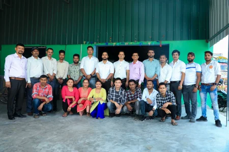 A group of Manakamana Beverage staff, standing and sitting in front of the Manakamana Beverage Factory.